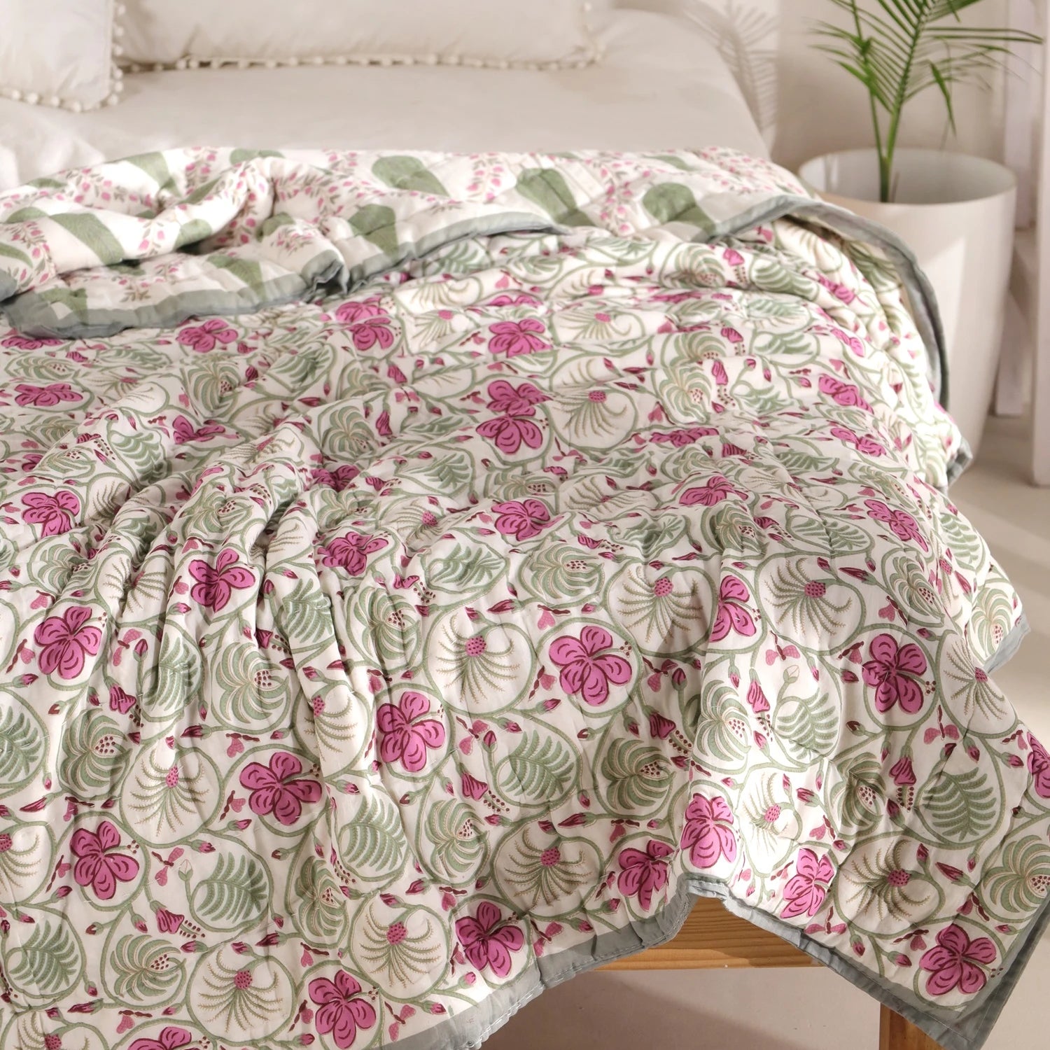 Jaipuri quilt in block print design with pink flowers on white background for single bed use