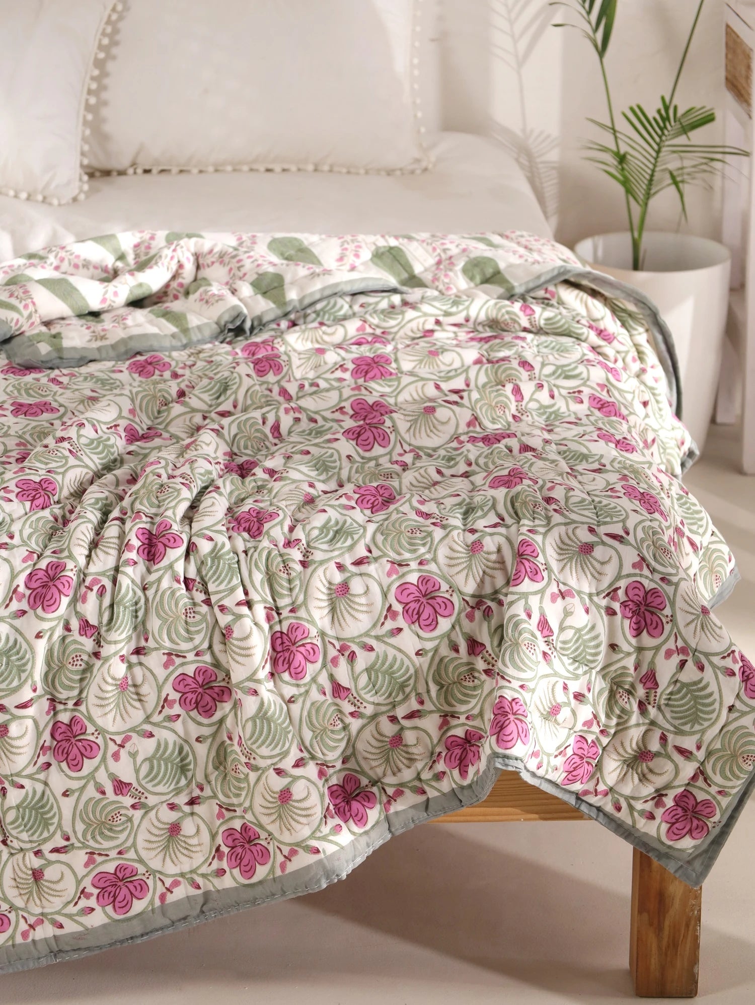 Jaipuri quilt in block print design with pink flowers on white background for single bed use